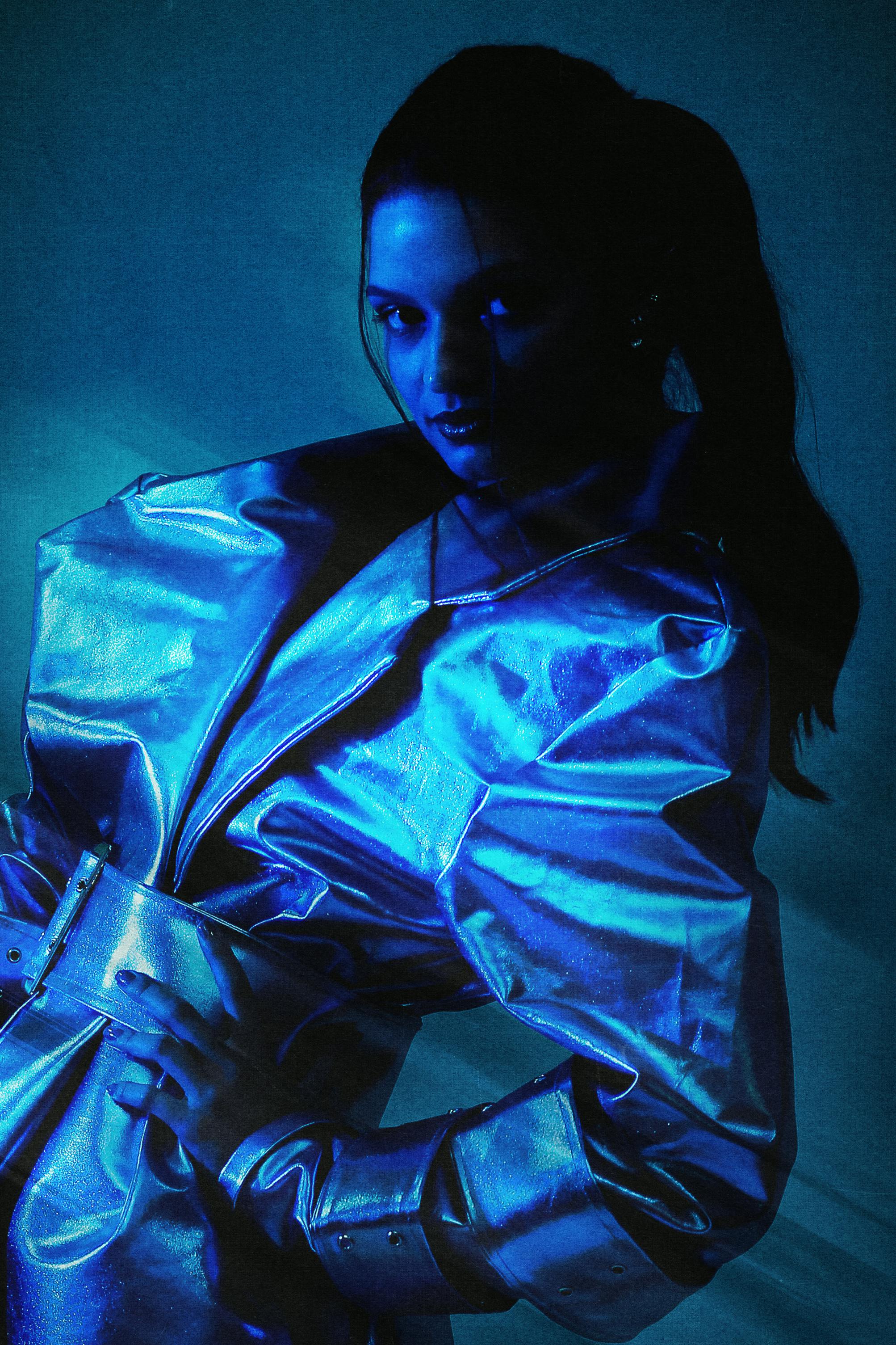 Striking image of a woman in futuristic metallic outfit with blue lighting.