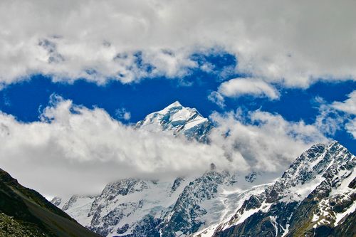 Free A captivating view of snow-covered mountain peaks under a dramatic sky with clouds. Stock Photo