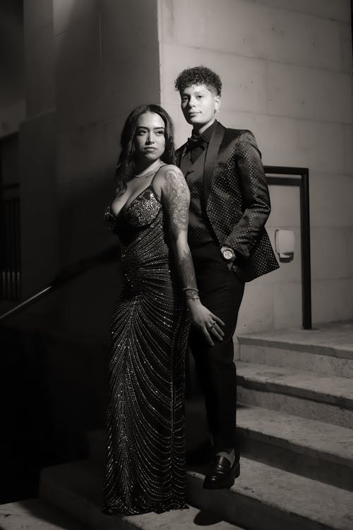 A man and woman in formal attire standing on stairs