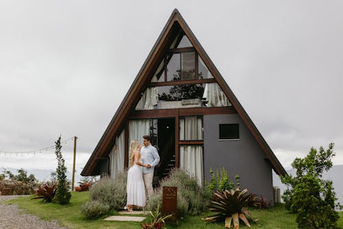 A couple standing in front of a small house