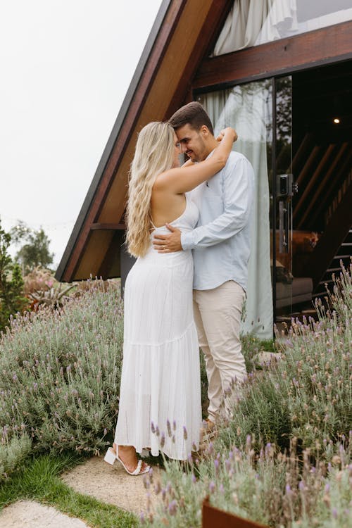 A couple embracing in front of a house with lavender