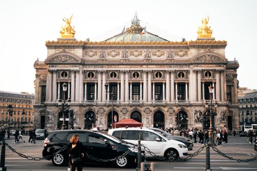 Free Stunning exterior of Palais Garnier in Paris showcasing its architectural grandeur and lively street scene. Stock Photo