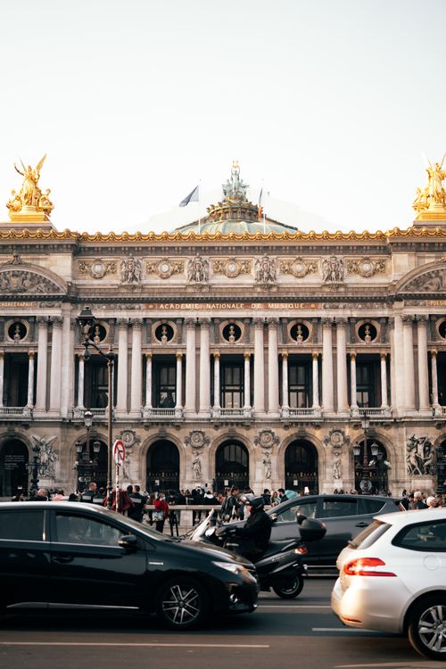 Free Capture of the iconic Palais Garnier in Paris with busy street view at dusk. Stock Photo