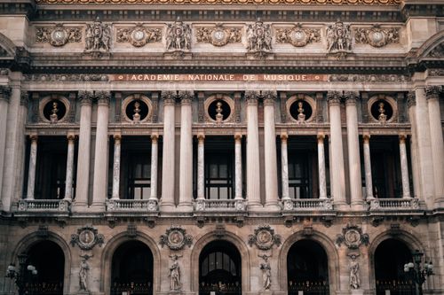 Free Detailed view of the Palais Garnier facade, highlighting its grand architecture and sculptures in Paris, France. Stock Photo