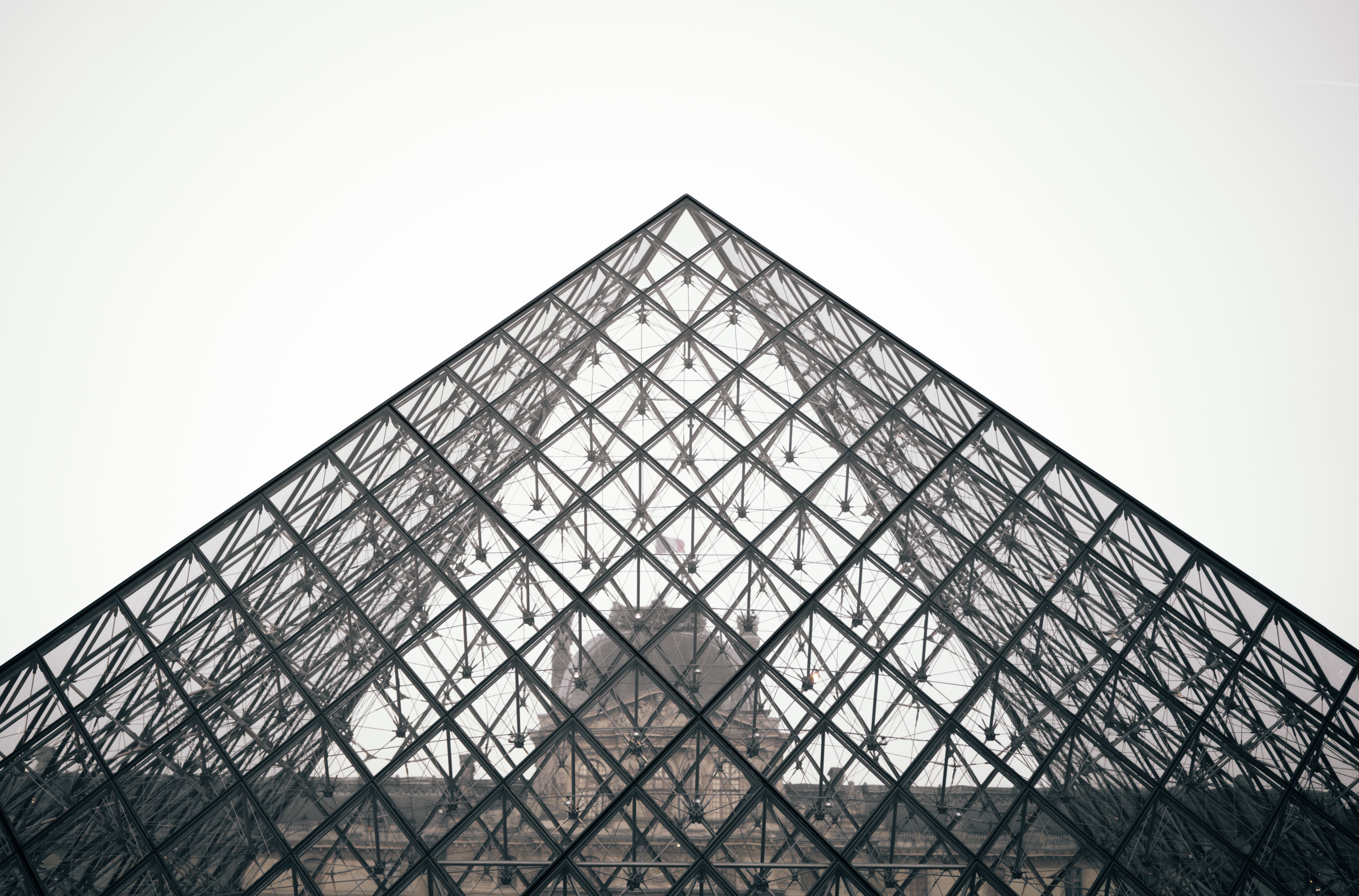 Close-up of the Louvre Pyramid showcasing its modern geometric design against a clear sky in Paris.