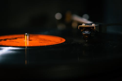 A close up of a record player with a orange disc