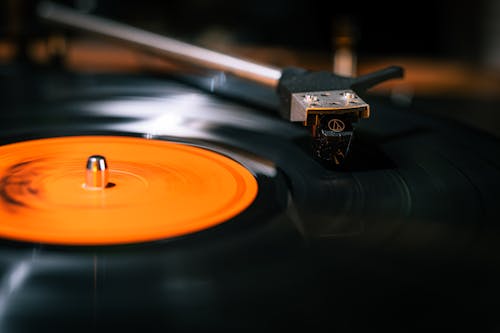 A close up of a record player with an orange disc