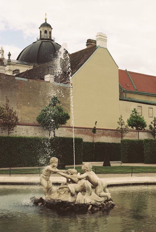 A fountain in front of a building with a statue