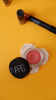 Luxury cosmetics displayed on a bold yellow background, showcasing elegance and style.