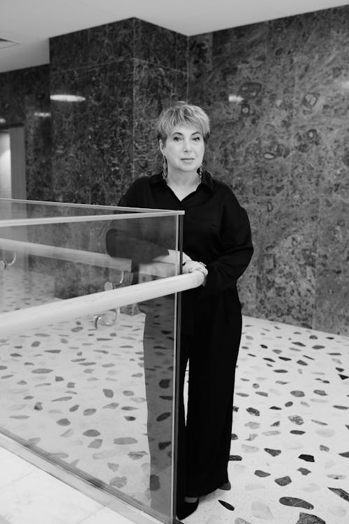 A woman standing in front of a glass wall