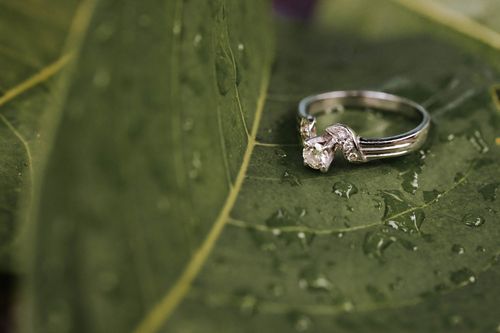 Free Close-up of a diamond ring on a green leaf with dew drops, showcasing luxury and elegance. Stock Photo