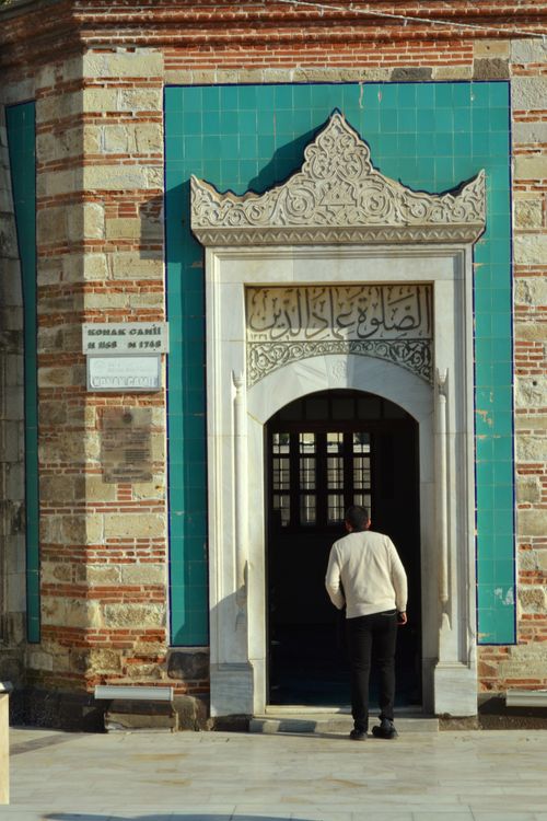 Free A man enters a historic mosque with intricate design elements and vibrant tiles. Stock Photo