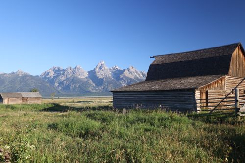 Free Scenic view of a wooden barn set against the stunning Grand Teton mountains in Jackson, Wyoming. Stock Photo