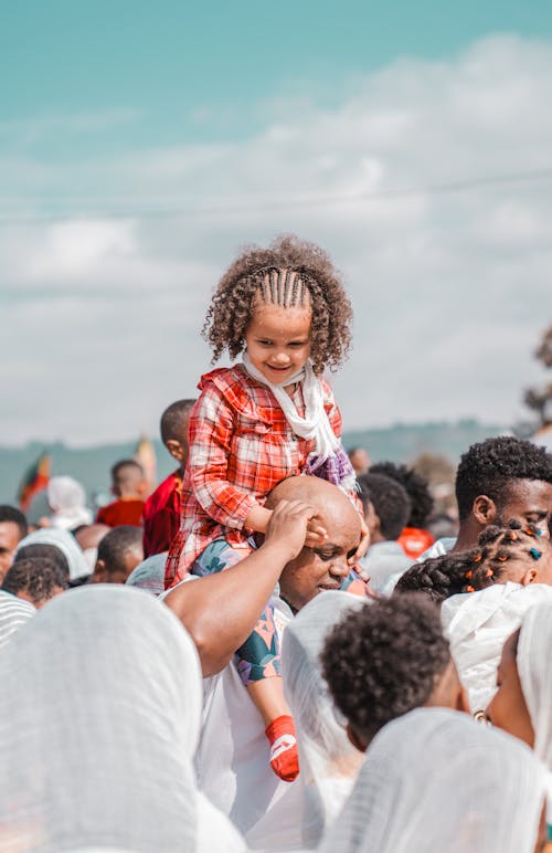 A young girl is being carried by her father