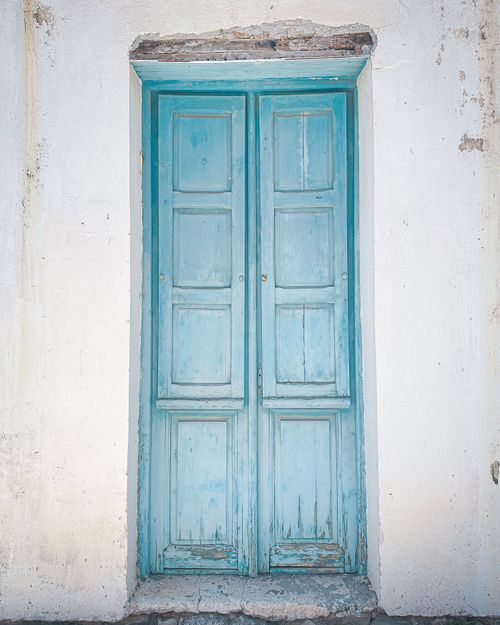 Free A classic, weathered blue door in Methoni, Greece, showcasing traditional Greek architecture. Stock Photo