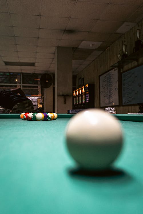 A pool table with balls on it and a green table