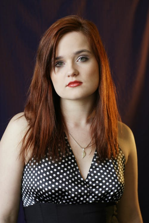 A woman with red hair and polka dot dress