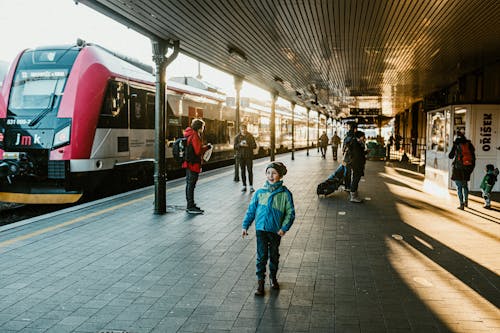 A young boy standing in front of a train station