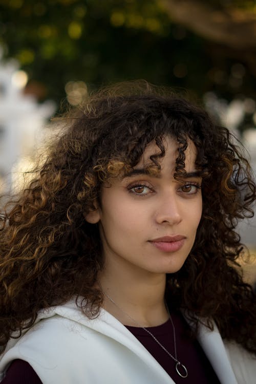 A woman with curly hair and a white shirt