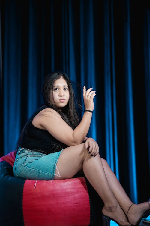 A woman sitting on a bean bag chair with her legs crossed