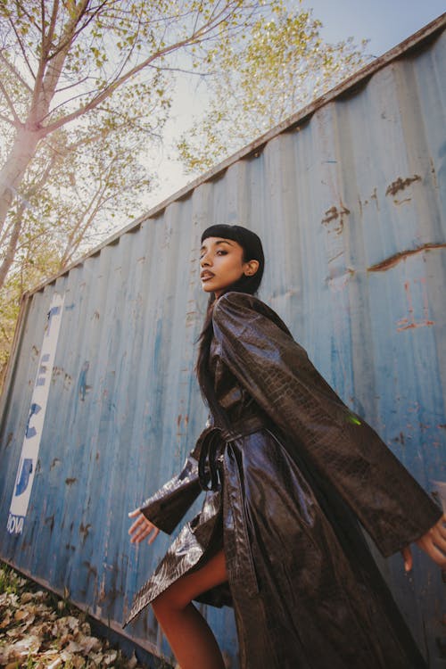 Brunette Woman in Black Leather Coat Posing by Cargo Container