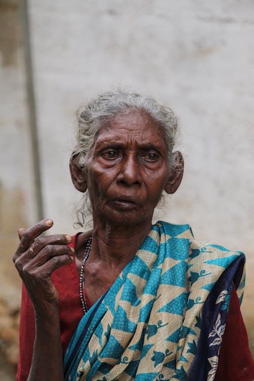 An old woman with a blue sari and a white sari