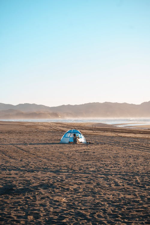 A tent on the beach with mountains in the background