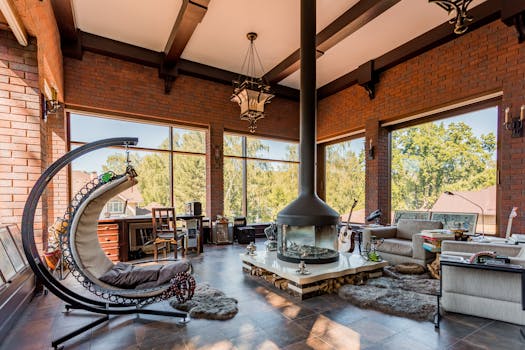 Elegant, sunlit interior with modern design, featuring a central fireplace and cozy swing chair.