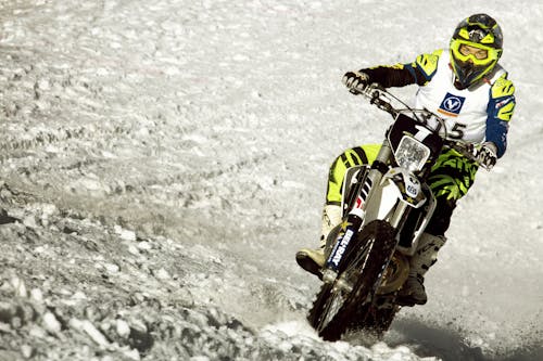 A Man Riding on a Dirt Bike in Snow 