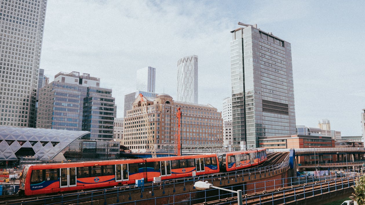 A train is traveling through a city with tall buildings