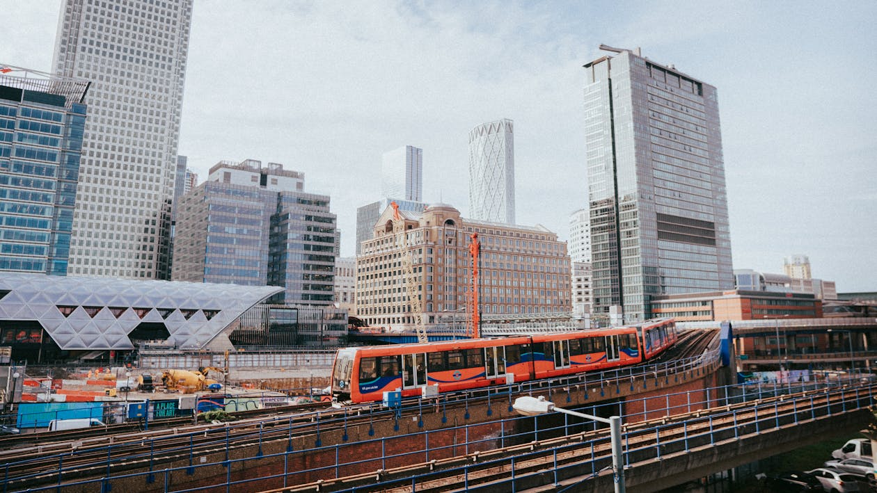 A train is traveling through a city with tall buildings