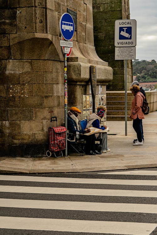 People and Road Signs near Building Wall