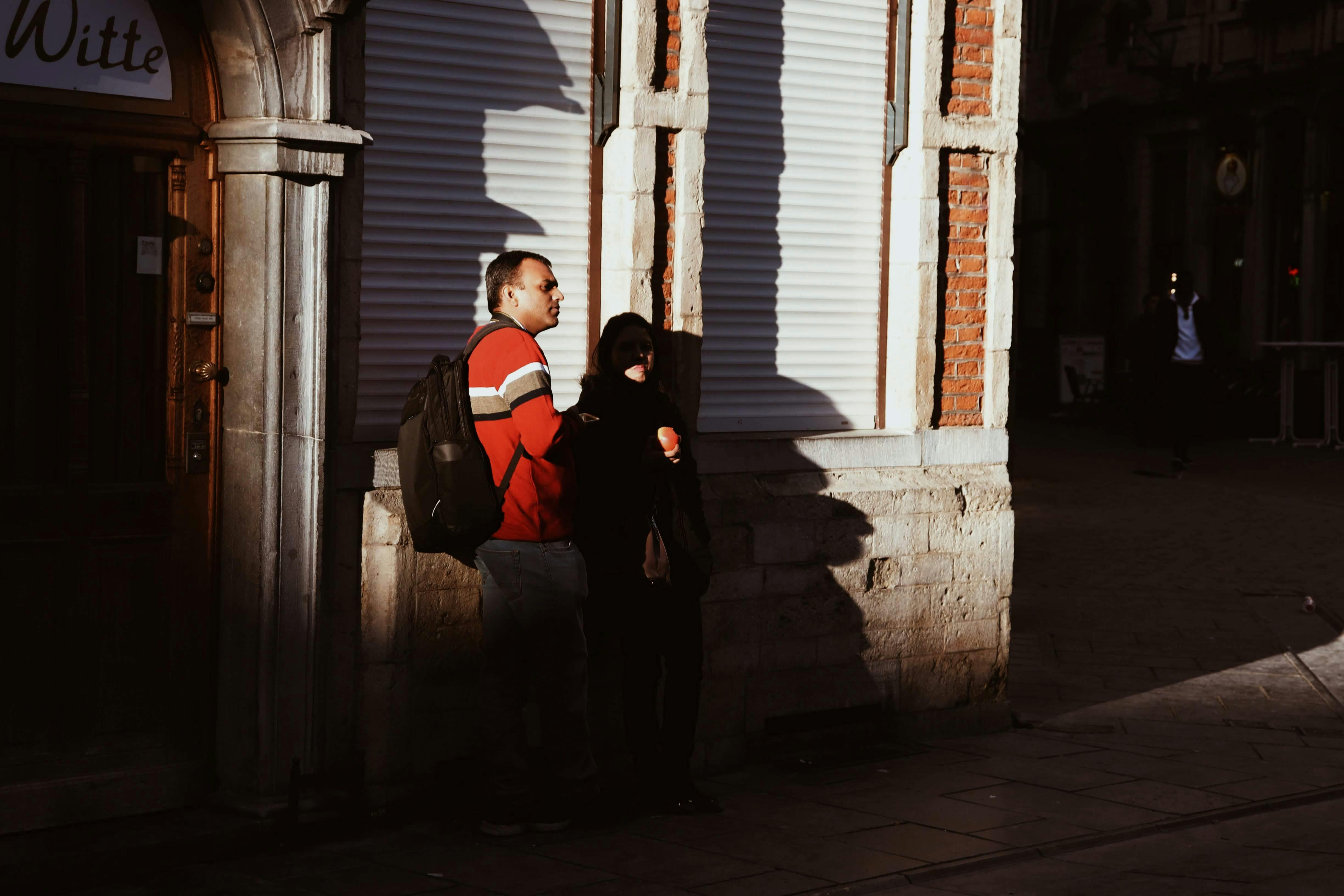 A man and a woman are standing outside of a building