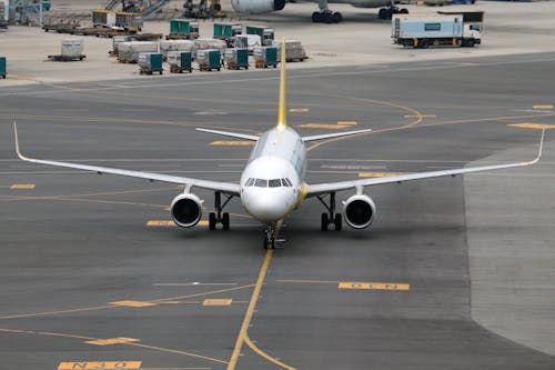 A white and yellow airplane sitting on the tarmac