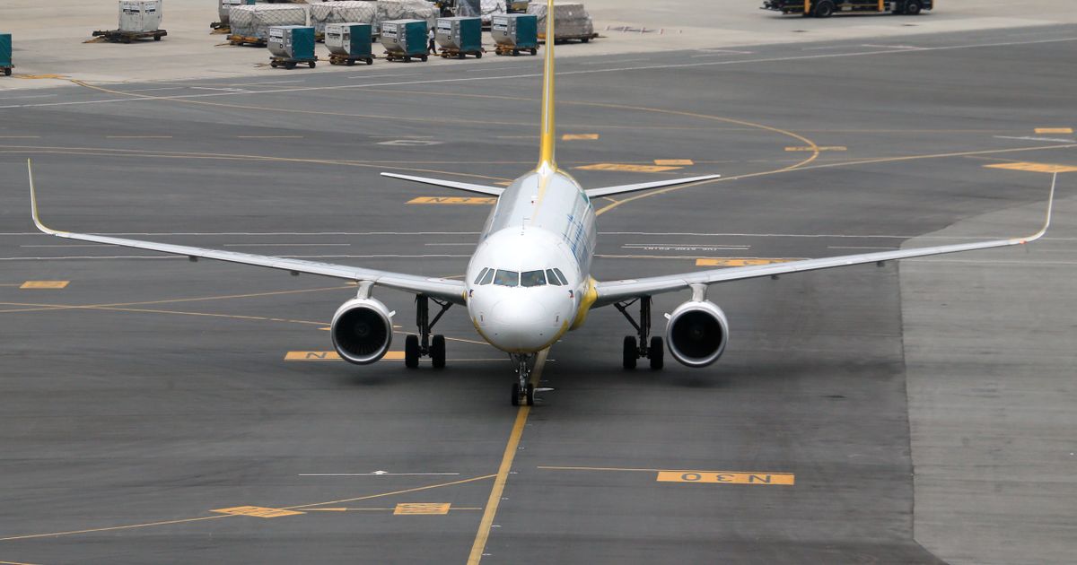 A commercial jet taxiing on the tarmac toward the runway.