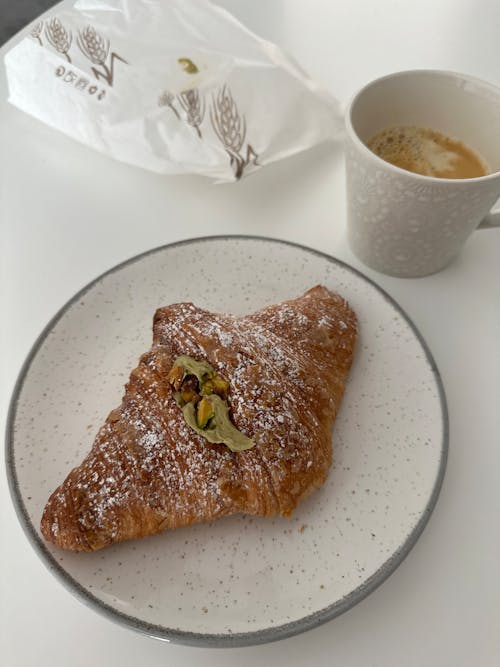 Croissant with Pistachio Filling and a Coffee in a Cafe