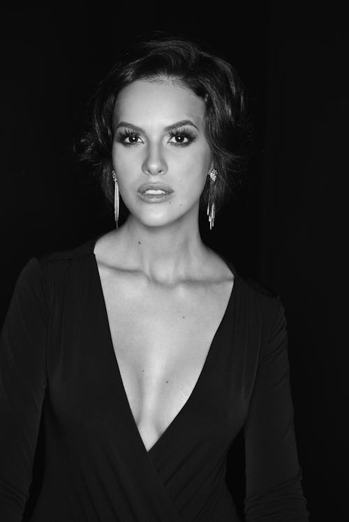 A woman in a black dress posing for a black and white photo