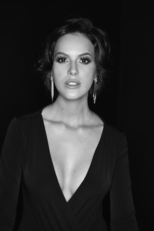 A woman in a black dress posing for a black and white photo