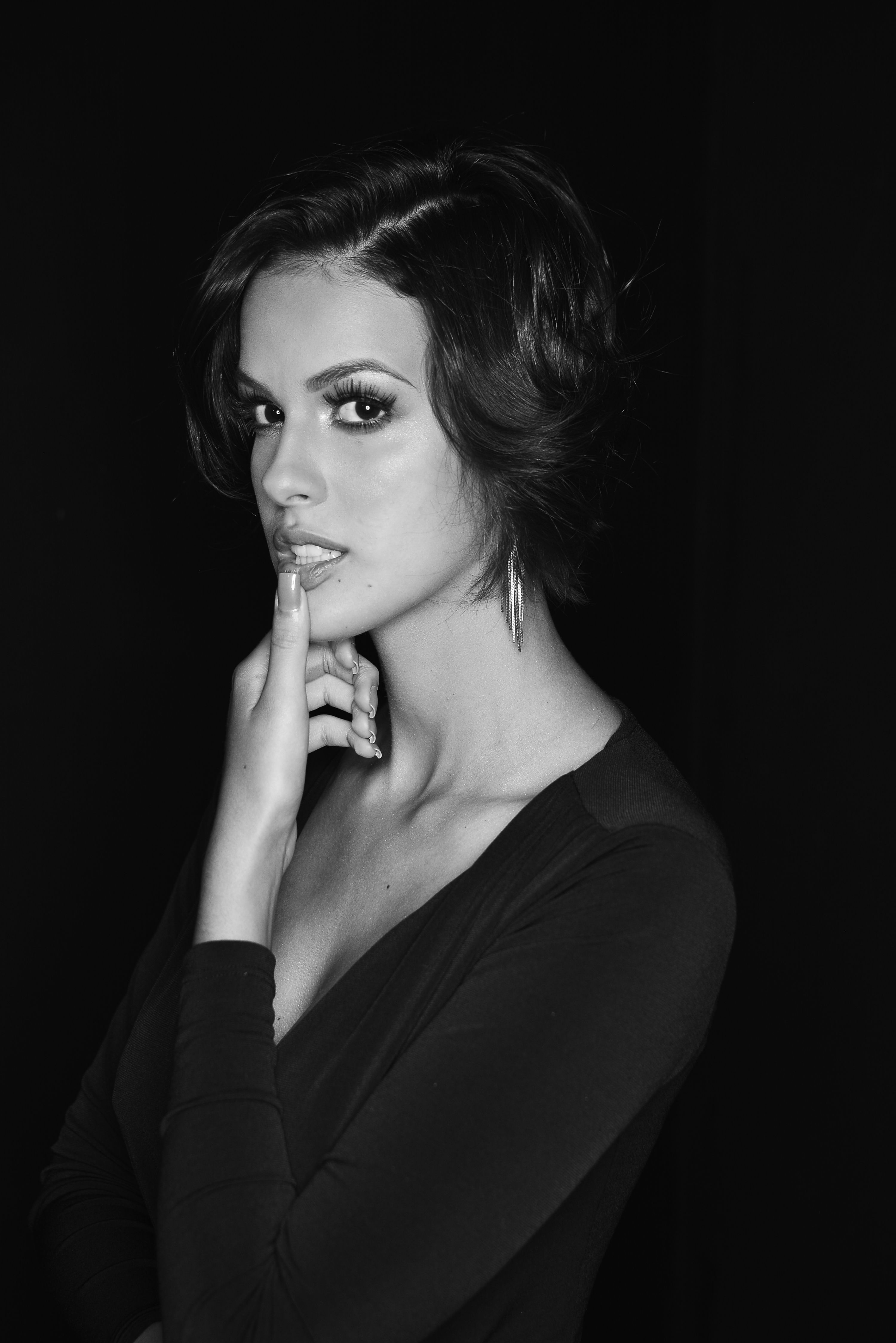 Glamorous black and white portrait of a woman posing gracefully.