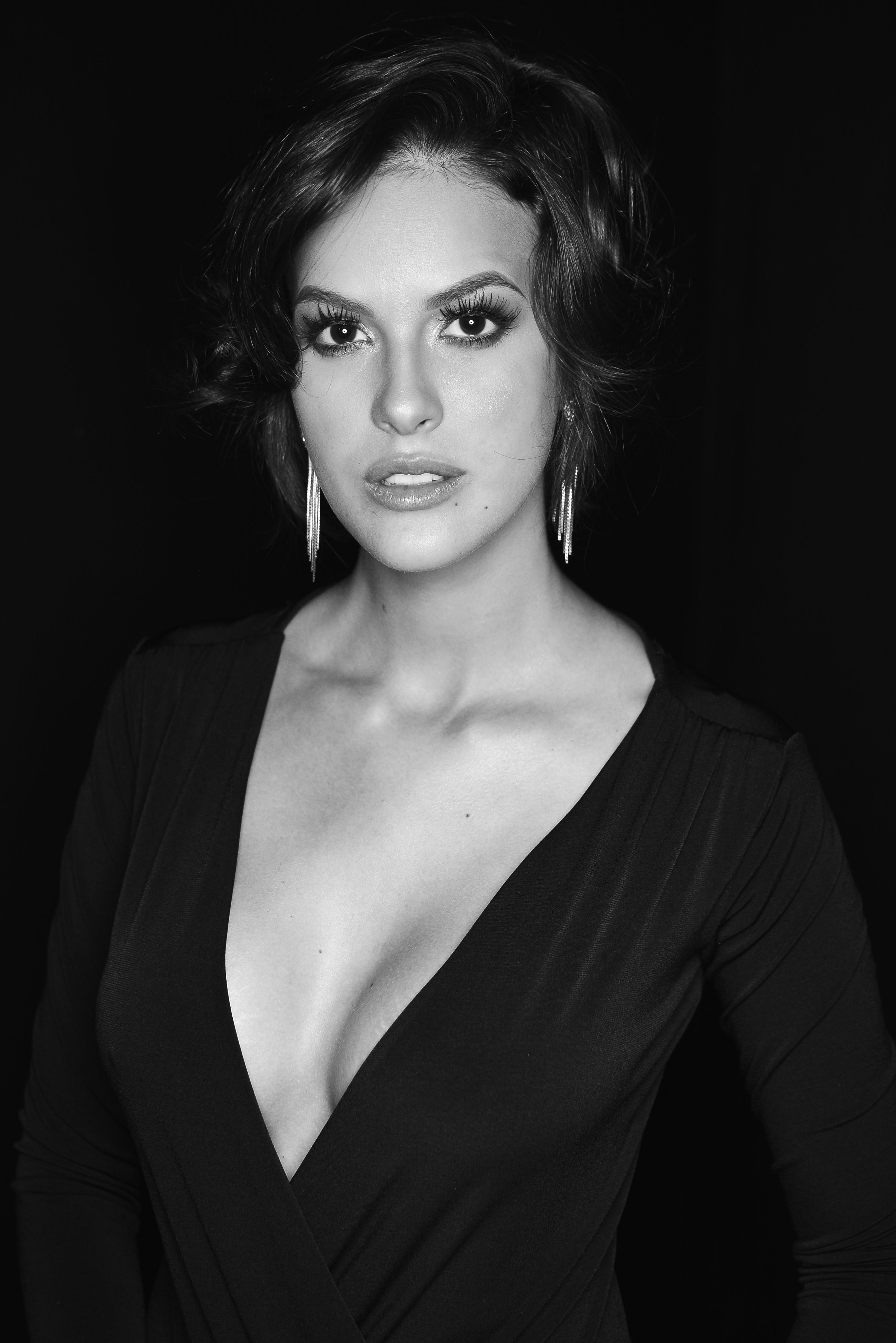 Striking black and white portrait of a woman posing with confidence and glamour.