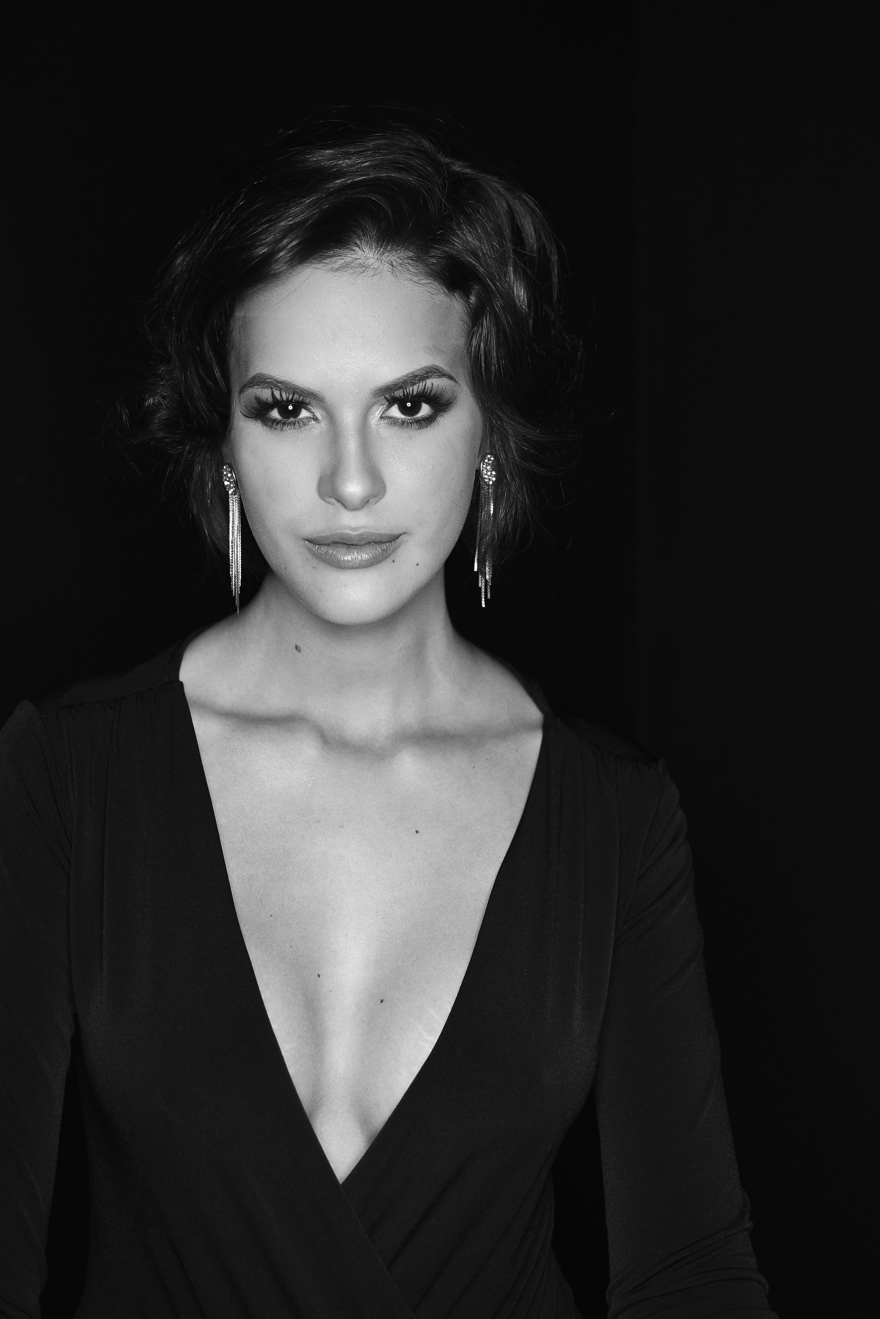 Striking black and white portrait of a woman in an evening dress, exuding elegance and grace.