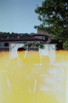 Capture of a romantic outdoor wedding ceremony with unique vintage light effects.