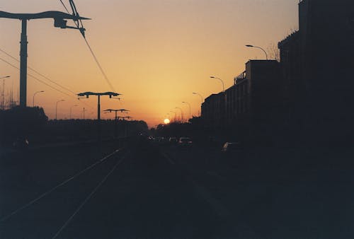 A sunset over a city street with power lines