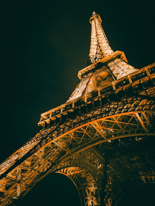 The eiffel tower is lit up at night