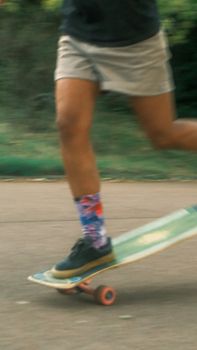 Close-up of a skateboarder in motion showcasing colorful socks and skateboard on a city street.