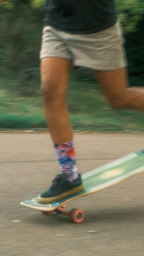 Free Close-up of a skateboarder in motion showcasing colorful socks and skateboard on a city street. Stock Photo
