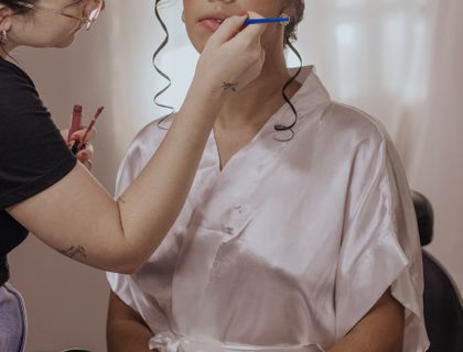 Bride having her makeup done by a beautician before her wedding