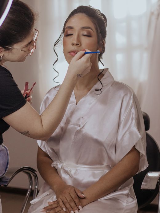 Bride having her makeup done by a beautician before her wedding