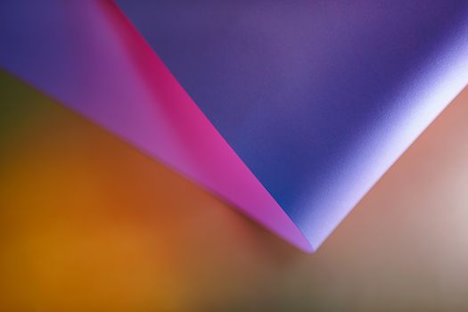 Colorful abstract geometric design featuring a blend of purple, pink, and orange hues.