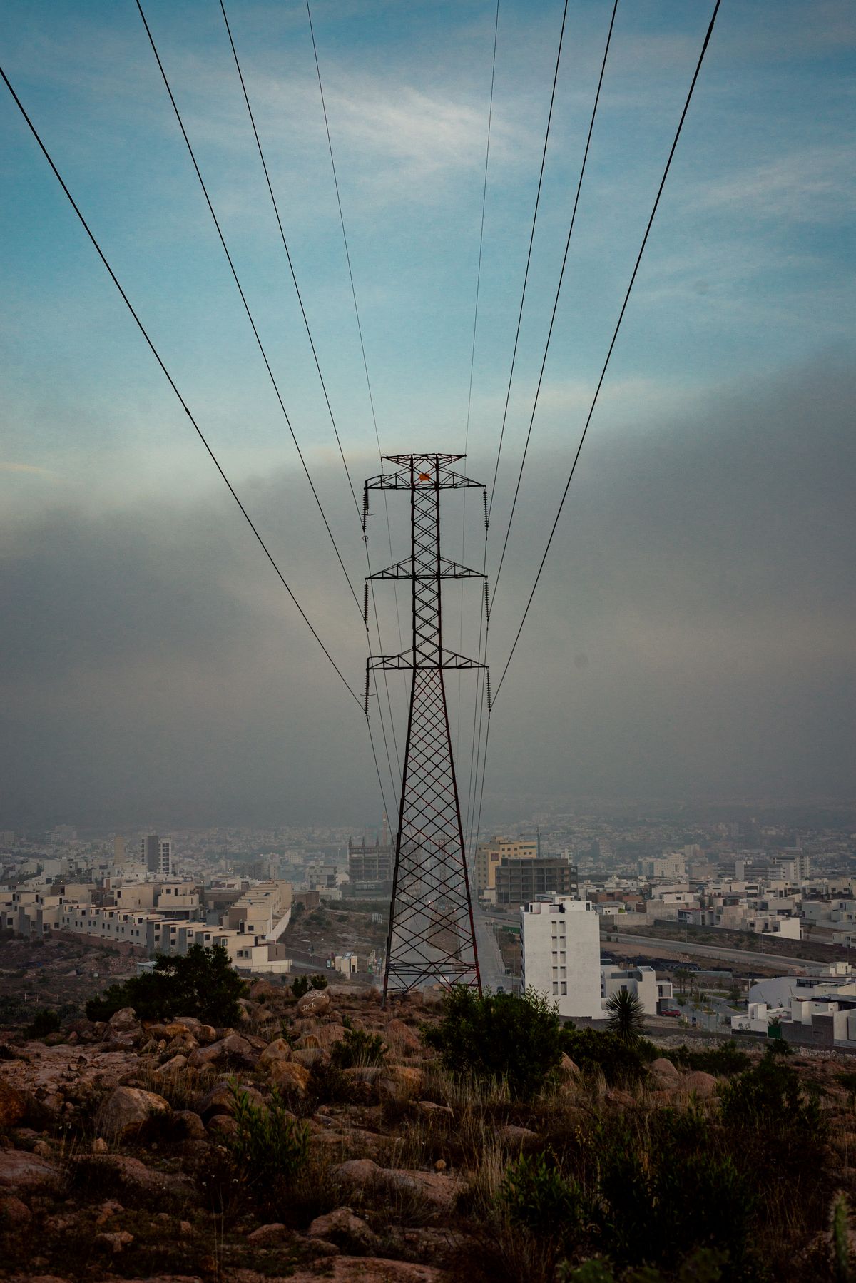 High-tension lines crossing an urban skyline